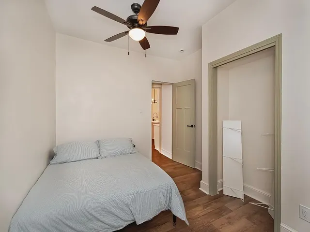 a bedroom with a bed and a ceiling fan