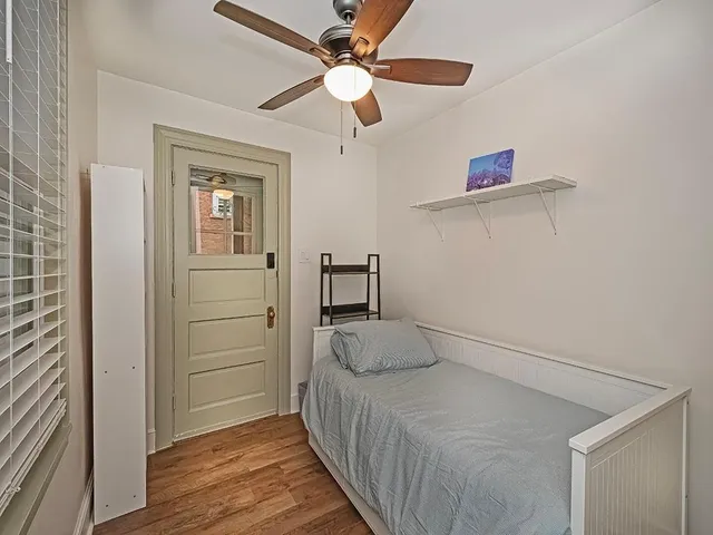 a bedroom with a bed and a ceiling fan