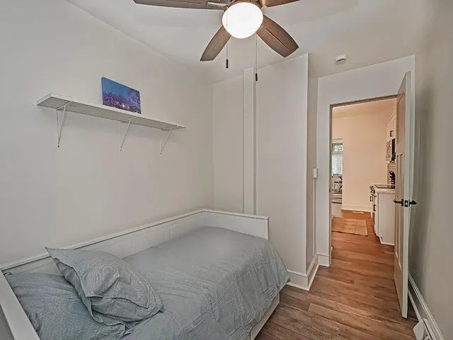a bedroom with a bed and wooden floor