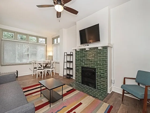 a living room with furniture a flat screen tv and a fireplace