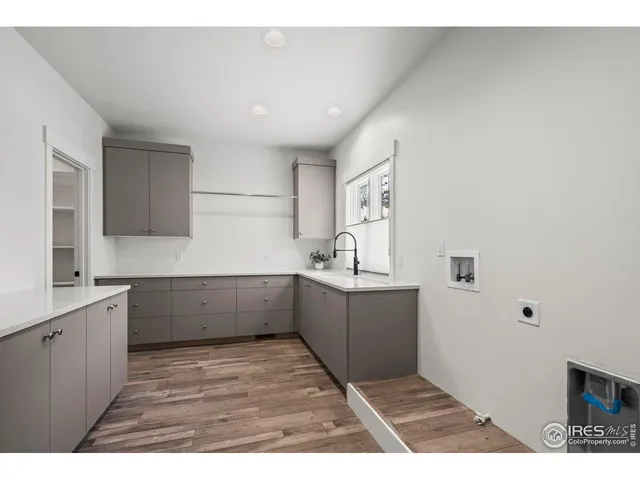 a kitchen with a wooden floor and cabinets
