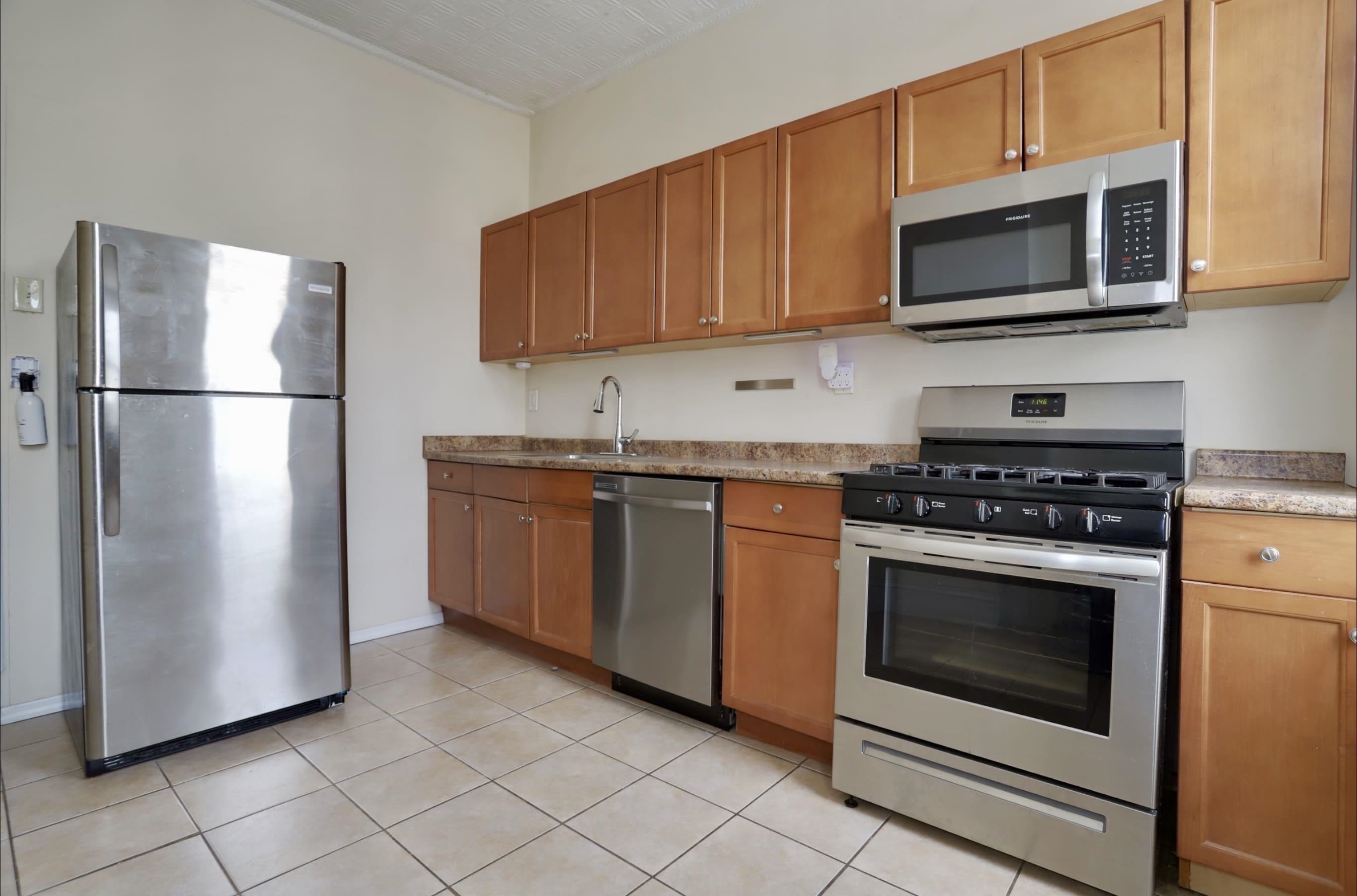 58 Prospect Street, Unit 2 Jersey City, NJ 07307 - Photo 21 of 26 a kitchen with stainless steel appliances granite countertop a stove microwave and refrigerator