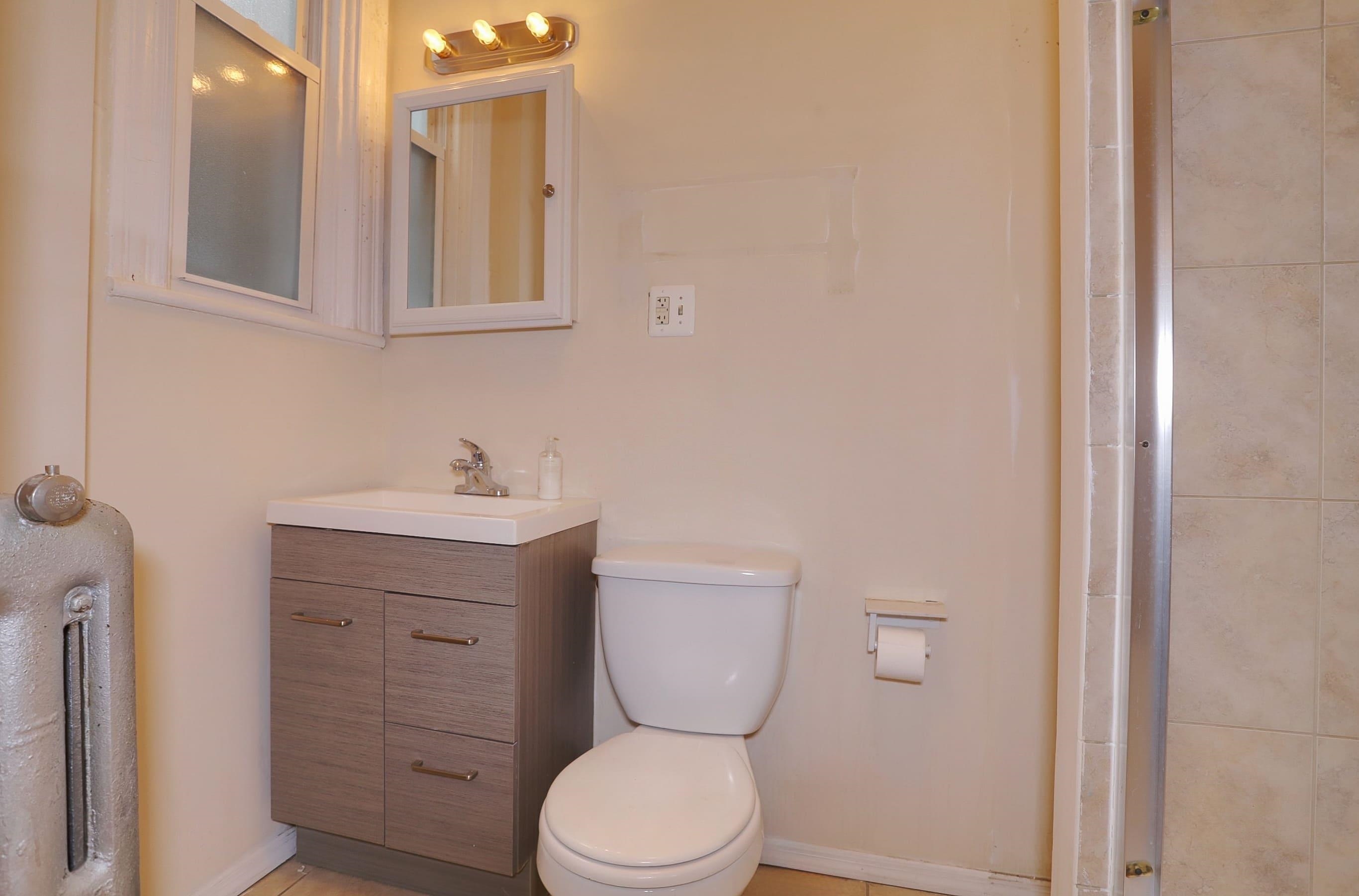 58 Prospect Street, Unit 2 Jersey City, NJ 07307 - Photo 8 of 26 a bathroom with a toilet sink and mirror