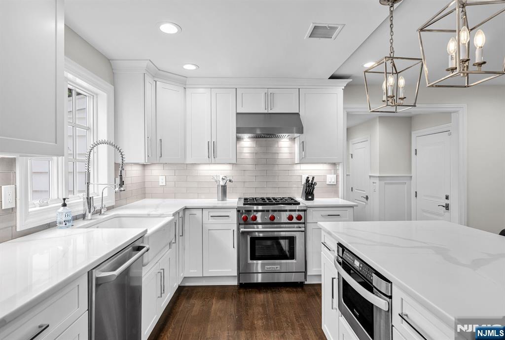 267 Merlin Place Wyckoff, NJ 07481 - Photo 21 of 49 a kitchen with stainless steel appliances a sink a stove and cabinets