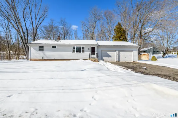 a white house with a large tree in front of it