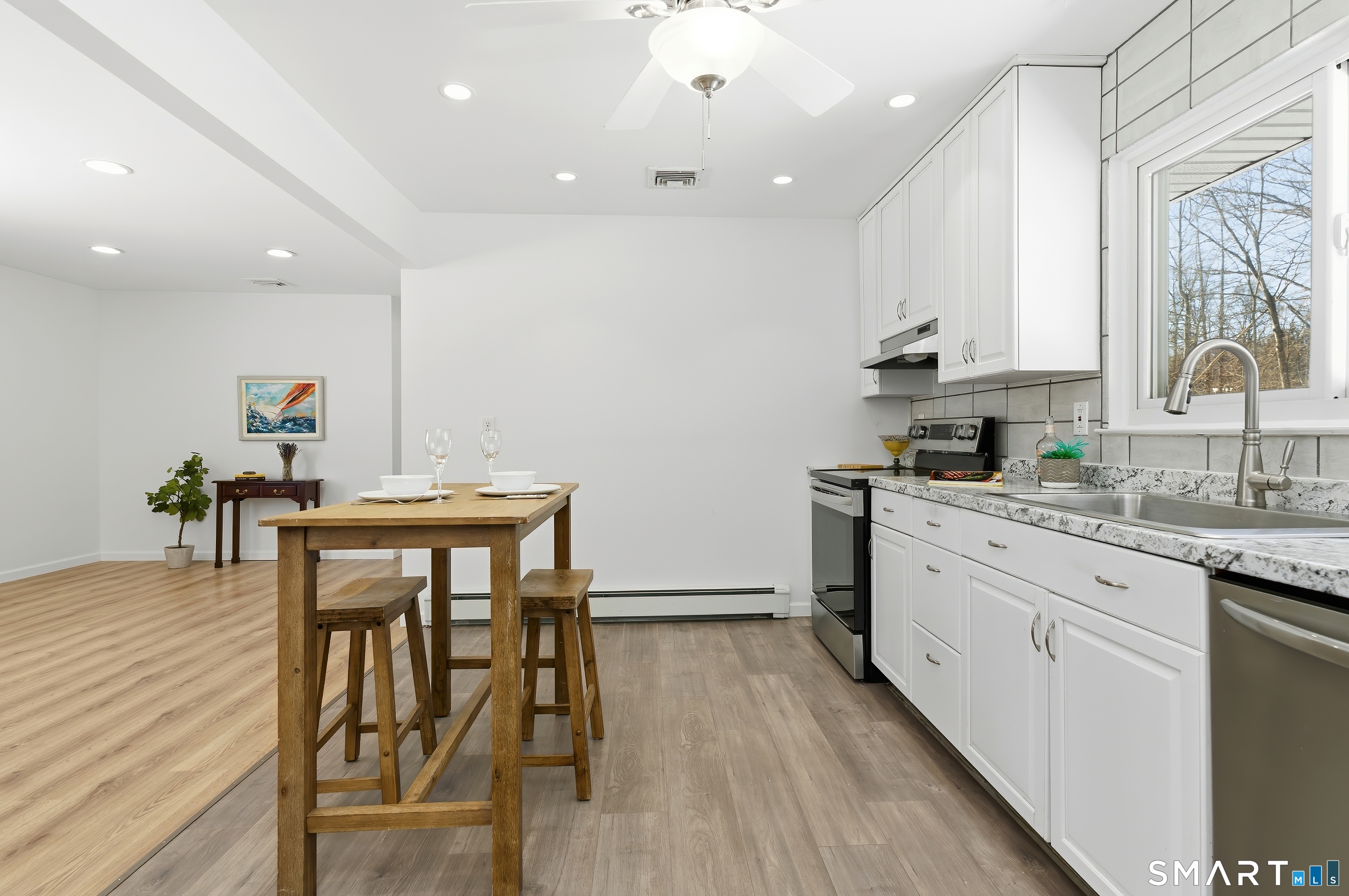 23 Ridgefield Road Wallingford, CT 06492 - Photo 13 of 28 a kitchen with stainless steel appliances kitchen island granite countertop a table chairs sink and cabinets