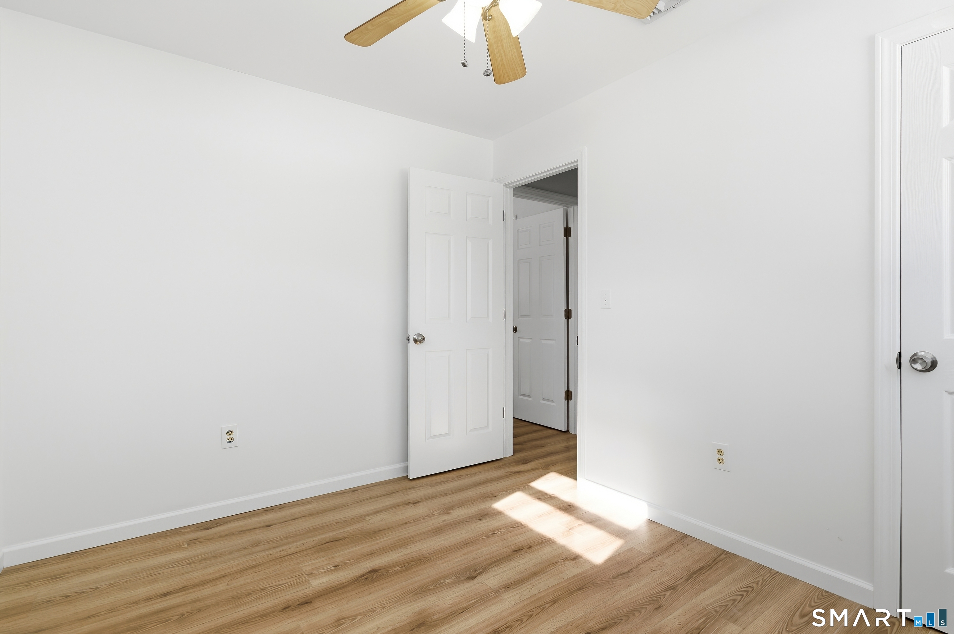 23 Ridgefield Road Wallingford, CT 06492 - Photo 22 of 28 a view of an empty room with wooden floor and a ceiling fan