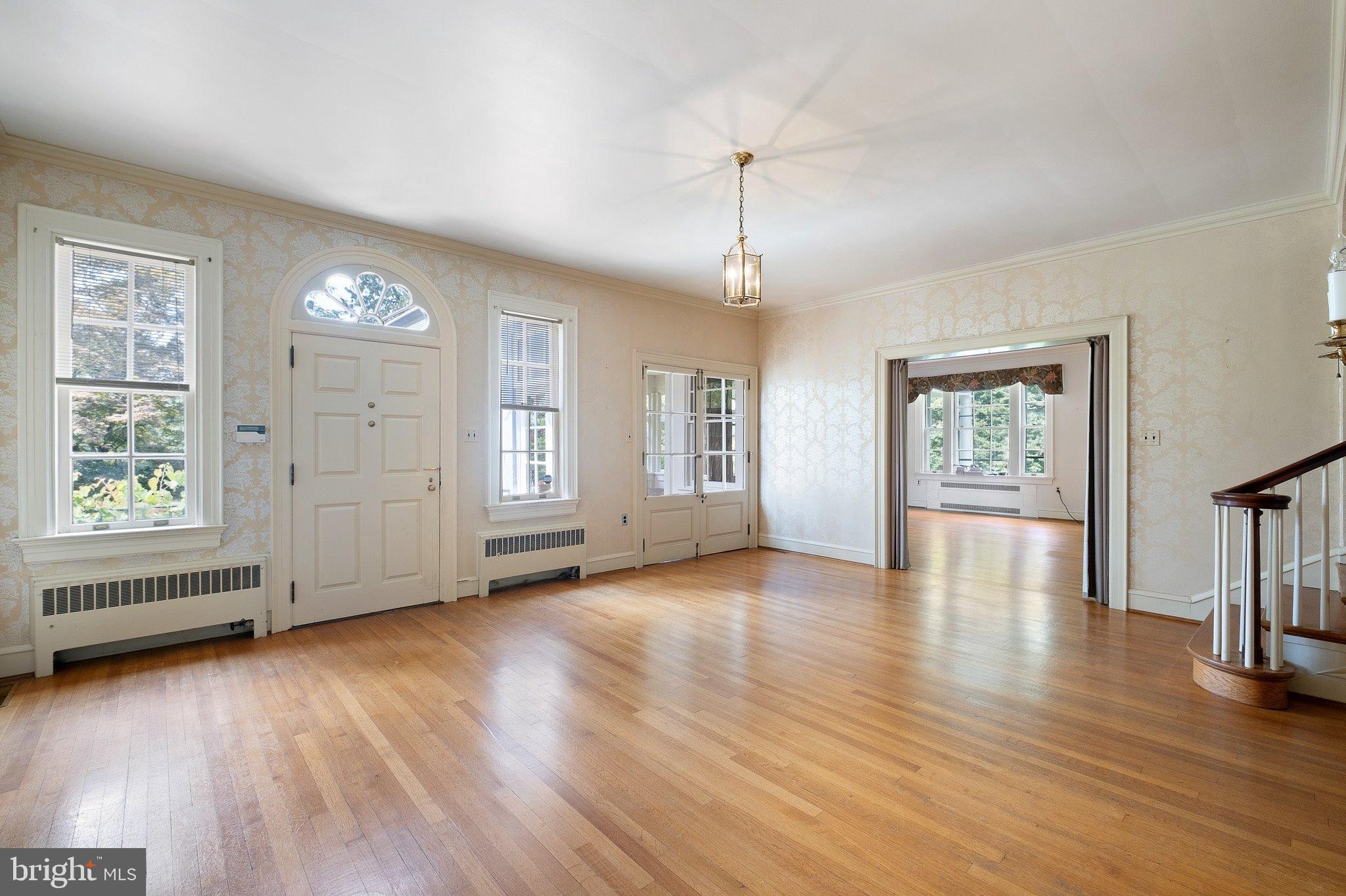 121 Gun Club Road Hockessin, DE 19707 - Photo 3 of 20 an empty room with wooden floor chandelier and windows
