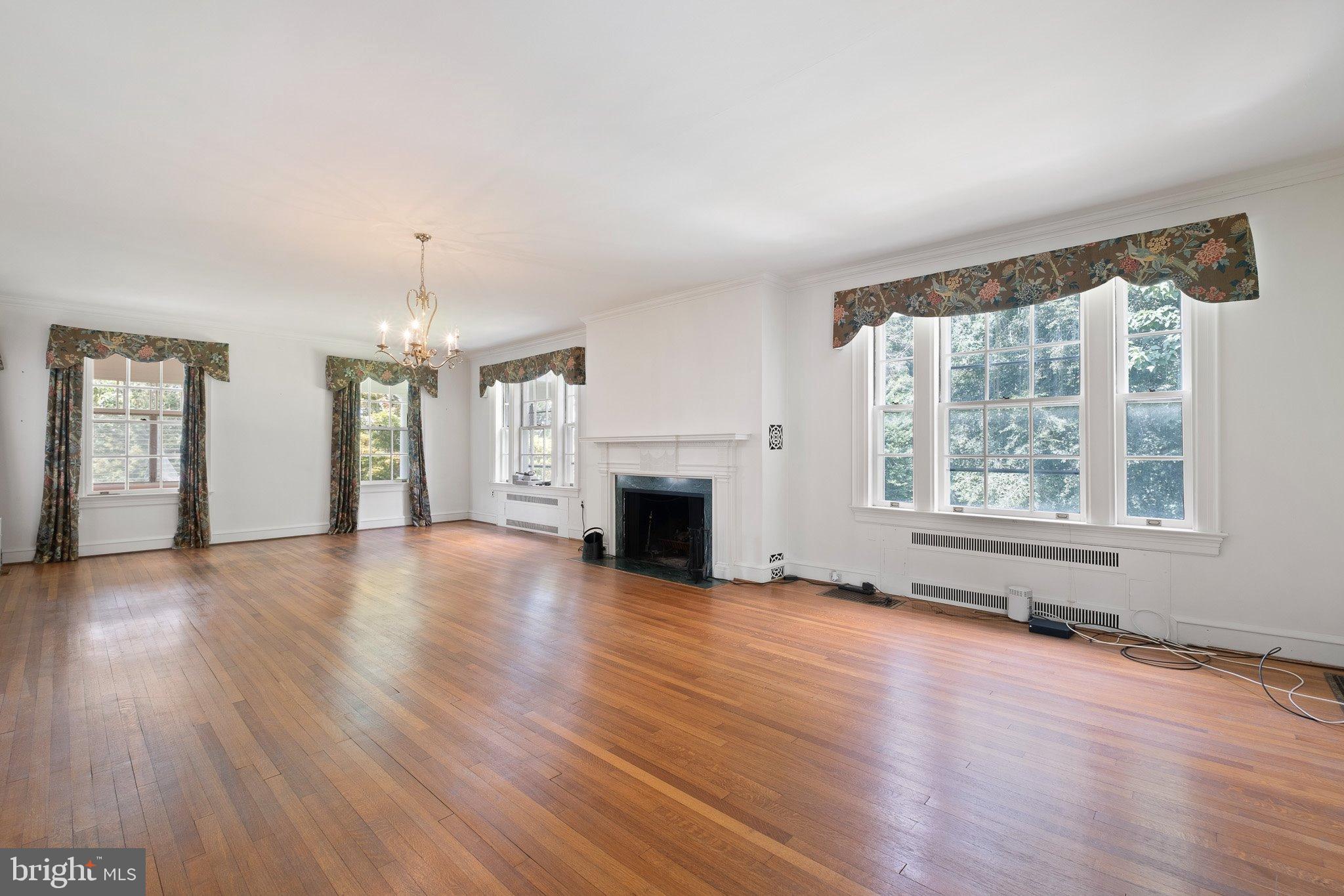 121 Gun Club Road Hockessin, DE 19707 - Photo 10 of 20 an empty room with wooden floor fireplace and windows