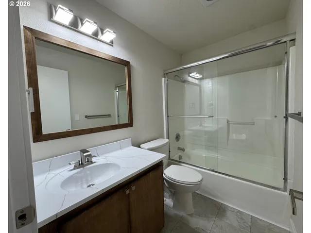 a bathroom with a sink a toilet and a large mirror