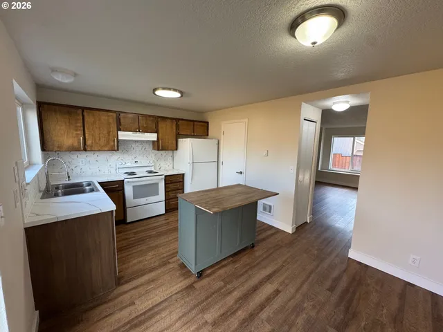 a kitchen with cabinets and wooden floor