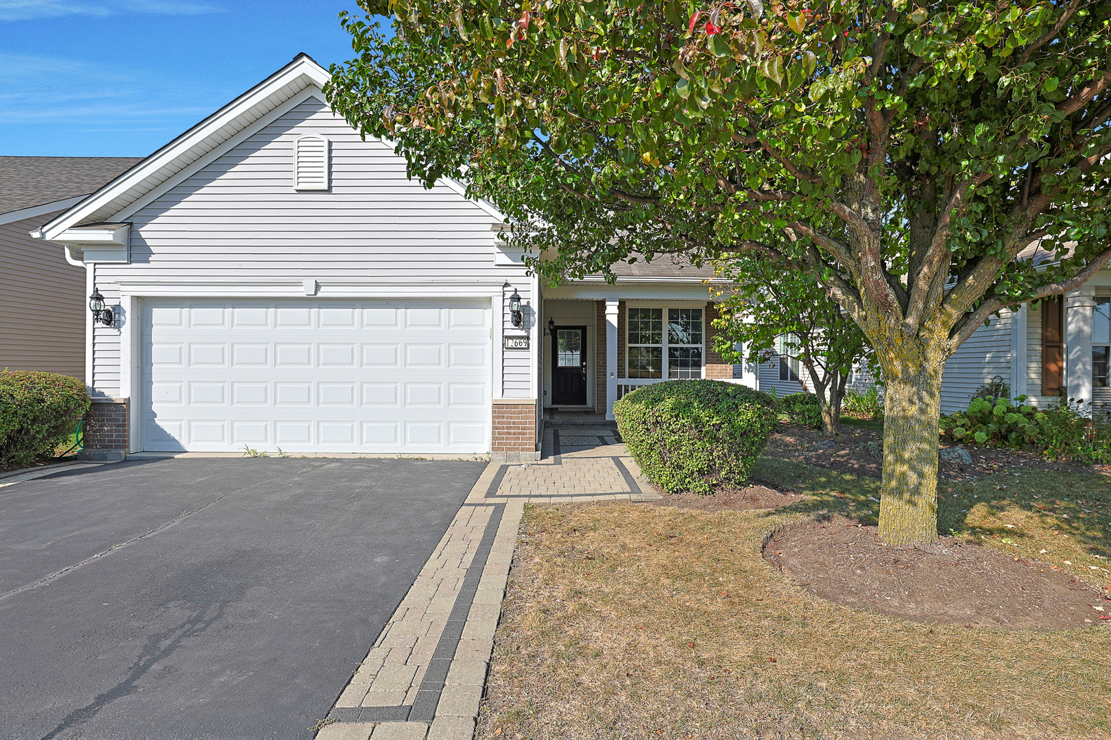 12669 Meritage Court Huntley, IL 60142 - Photo 2 of 33 a front view of a house with a yard and potted plants