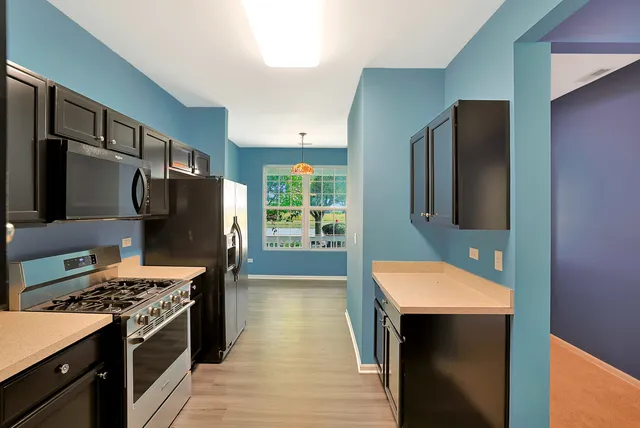 a kitchen with stainless steel appliances a stove a refrigerator and a cabinets