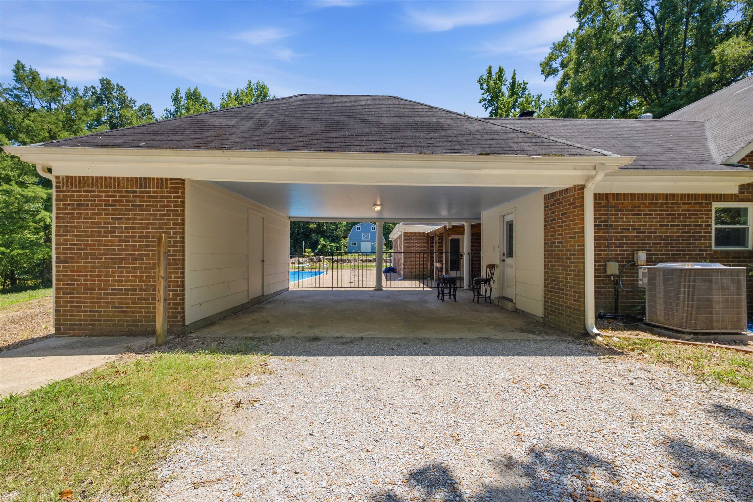 1370 North Reid Hooker Road Eads, TN 38028 - Photo 38 of 39 Covered carport with brick exterior walls, leading to a fenced pool area