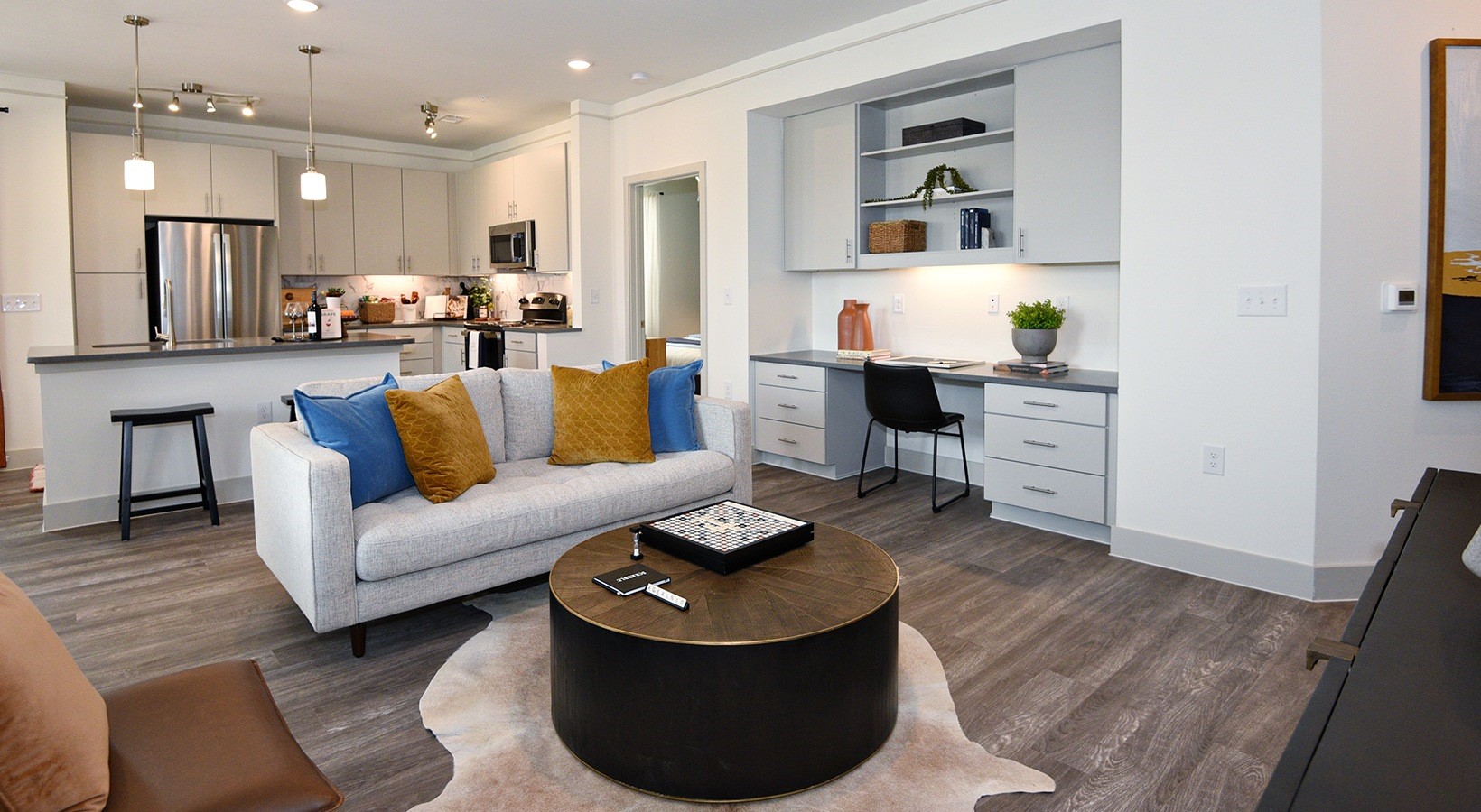 a living room with furniture and a dining table with wooden floor