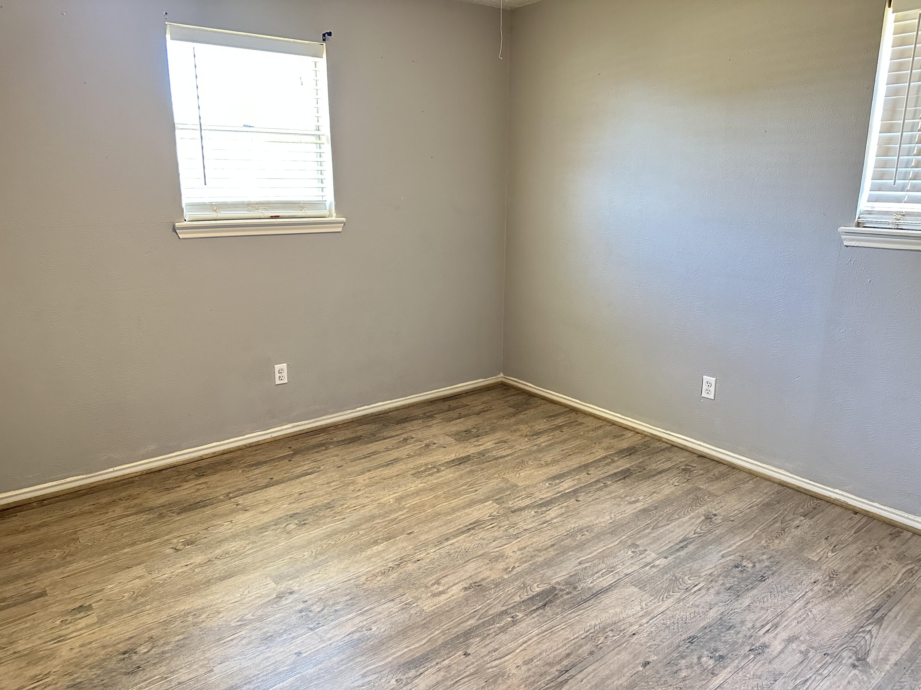 5613 16th Place Lubbock, TX 79416 - Photo 11 of 14 an empty room with wooden floor and a window