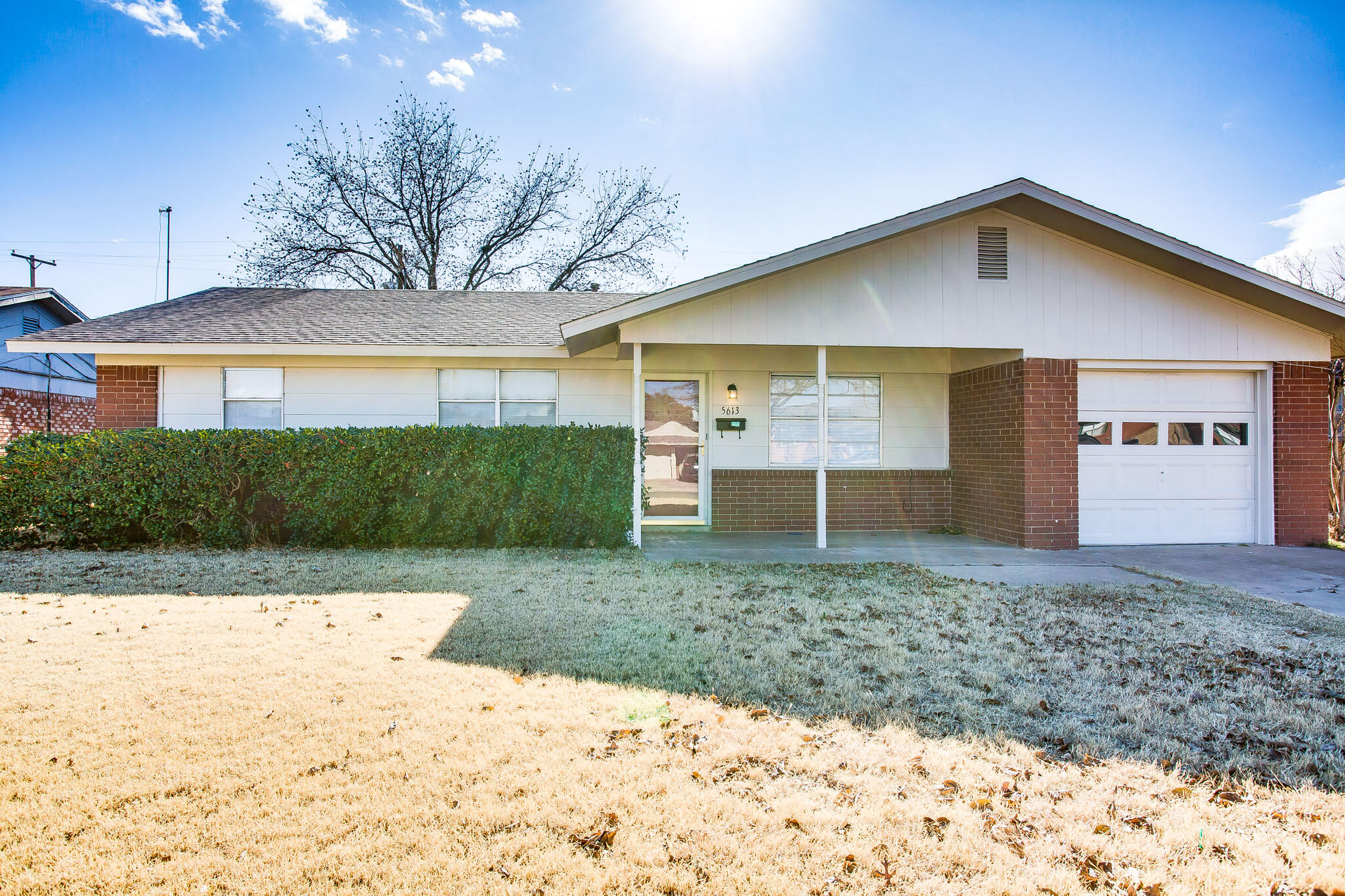 5613 16th Place Lubbock, TX 79416 - Photo 2 of 14 a front view of a house with a yard and garage