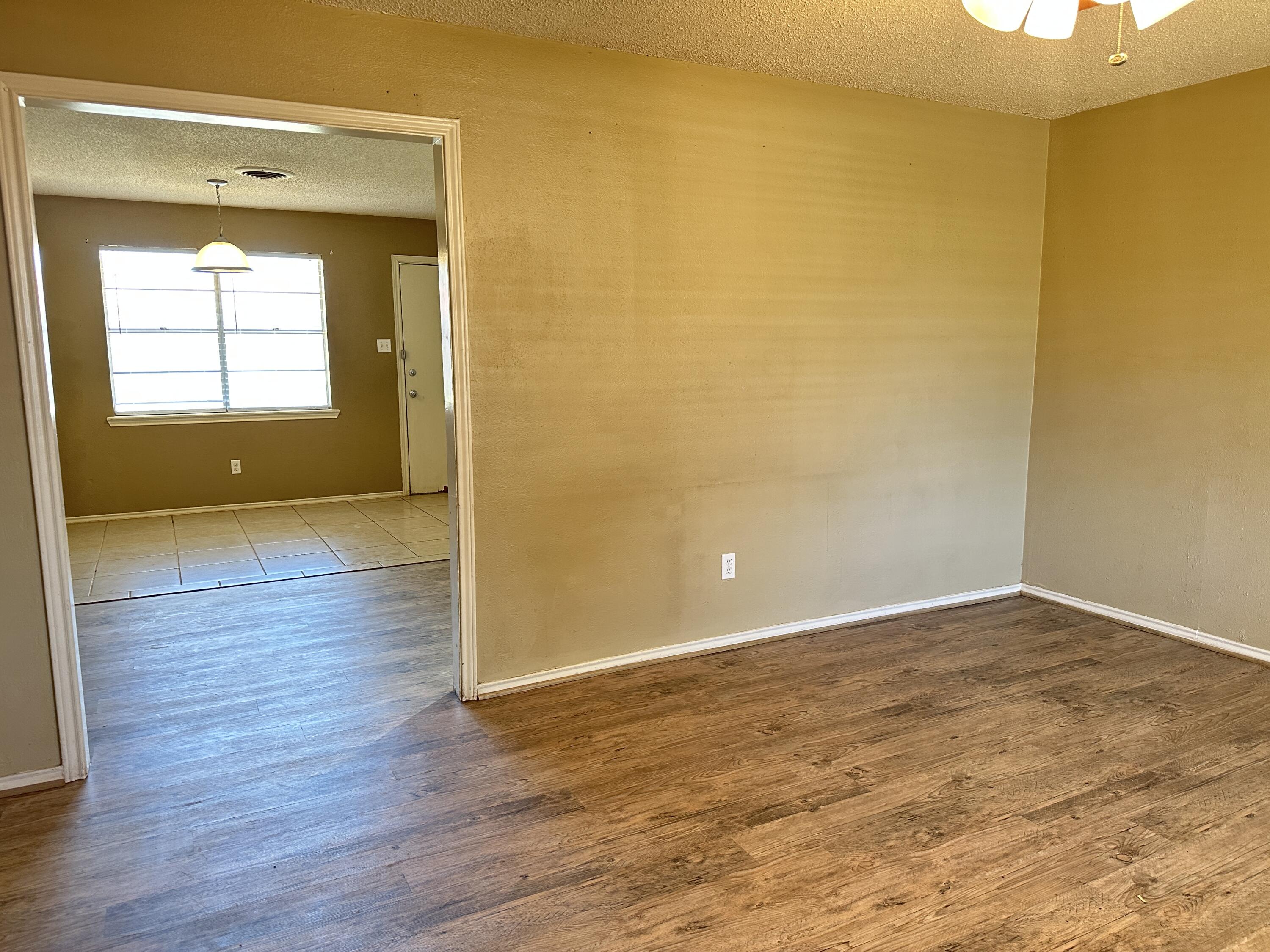 5613 16th Place Lubbock, TX 79416 - Photo 4 of 14 a view of a room with wooden floor and a window