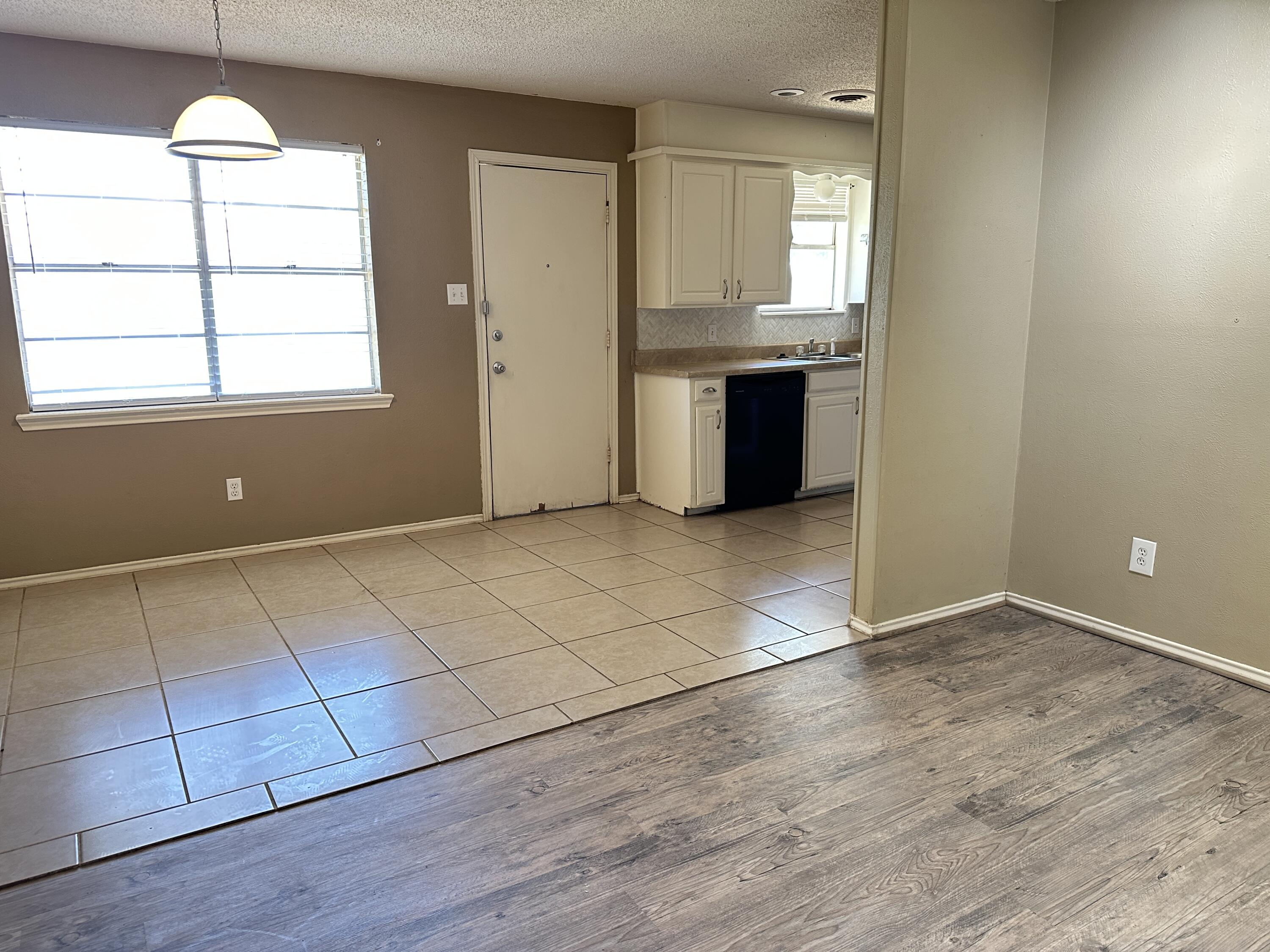 5613 16th Place Lubbock, TX 79416 - Photo 5 of 14 an empty room with wooden floor cabinet and windows