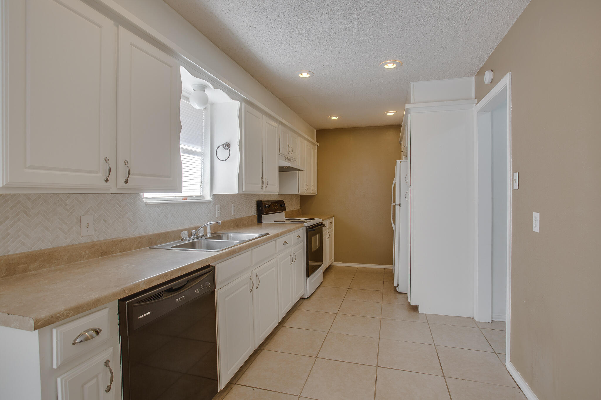 5613 16th Place Lubbock, TX 79416 - Photo 6 of 14 a kitchen with a sink a stove and cabinets