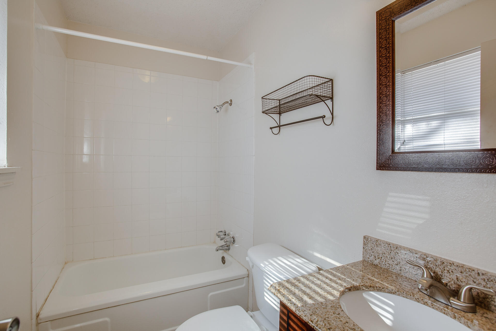 5613 16th Place Lubbock, TX 79416 - Photo 9 of 14 a bathroom with a granite countertop sink mirror vanity and toilet