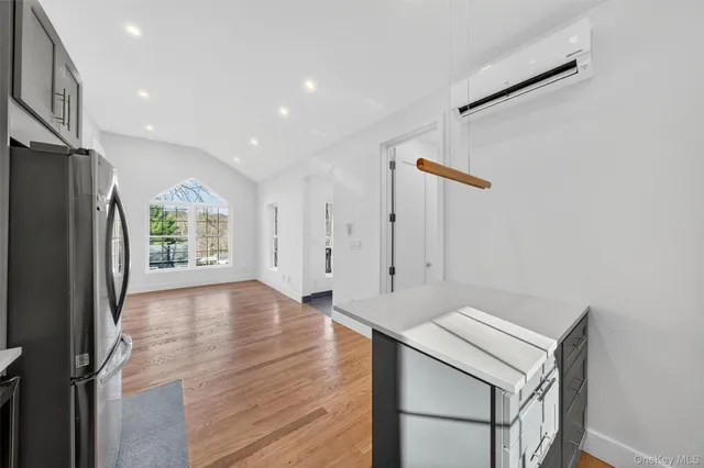 a kitchen with stainless steel appliances kitchen island granite countertop a refrigerator a sink a stove and a microwave