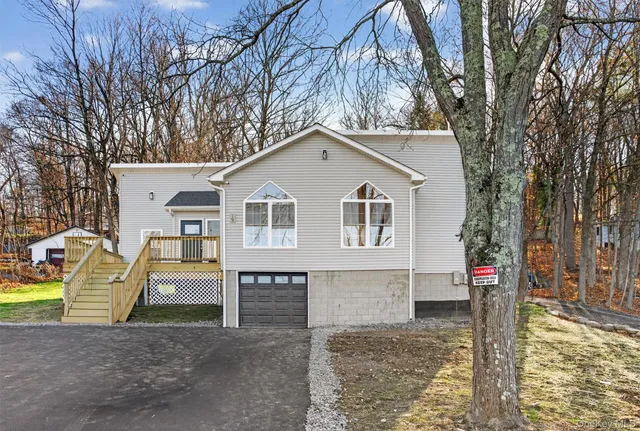 a white house that has tree in front of it