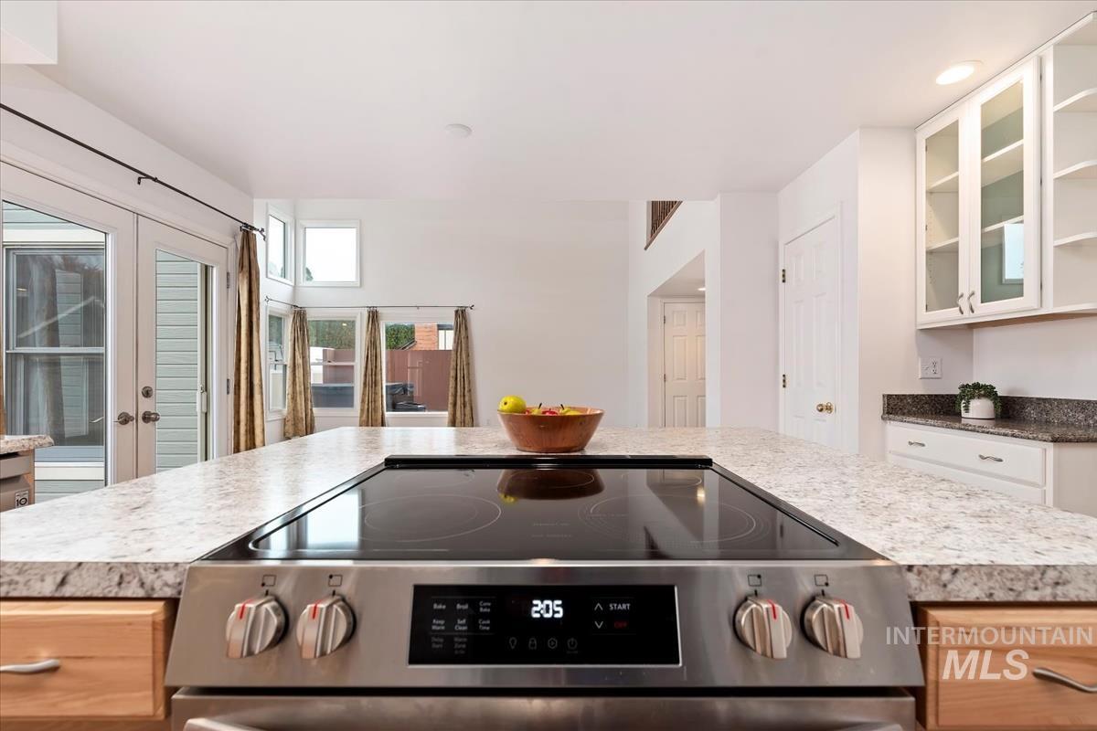 7790 Ustick Road Nampa, ID 83687 - Photo 11 of 41 Kitchen featuring stainless steel electric stove, glass insert cabinets, light countertops, and french doors