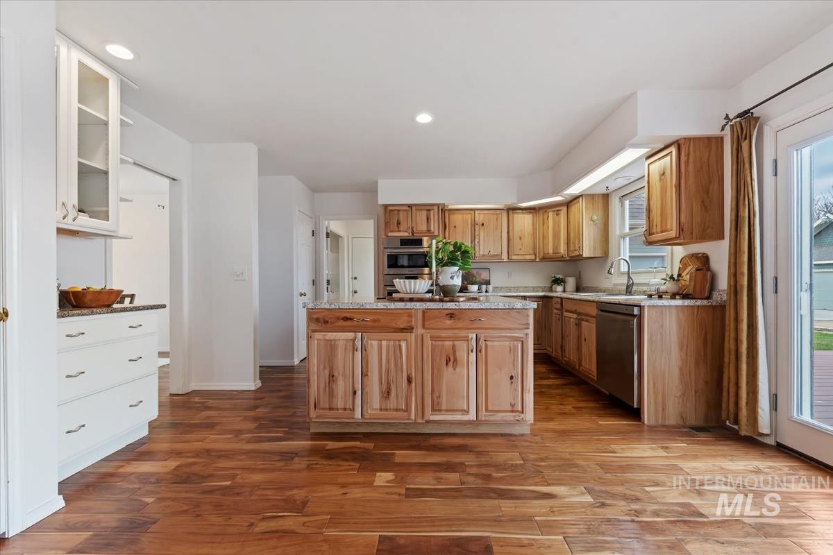 7790 Ustick Road Nampa, ID 83687 - Photo 12 of 41 Kitchen with dark wood-style flooring, glass insert cabinets, a center island, recessed lighting, and dishwasher