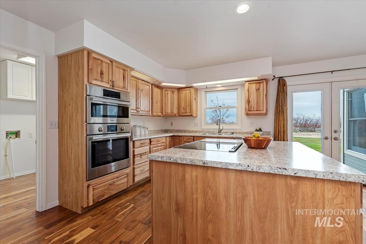 7790 Ustick Road Nampa, ID 83687 - Photo 13 of 41 Kitchen with a center island, stainless steel double oven, dark wood finished floors, black electric stovetop, and french doors