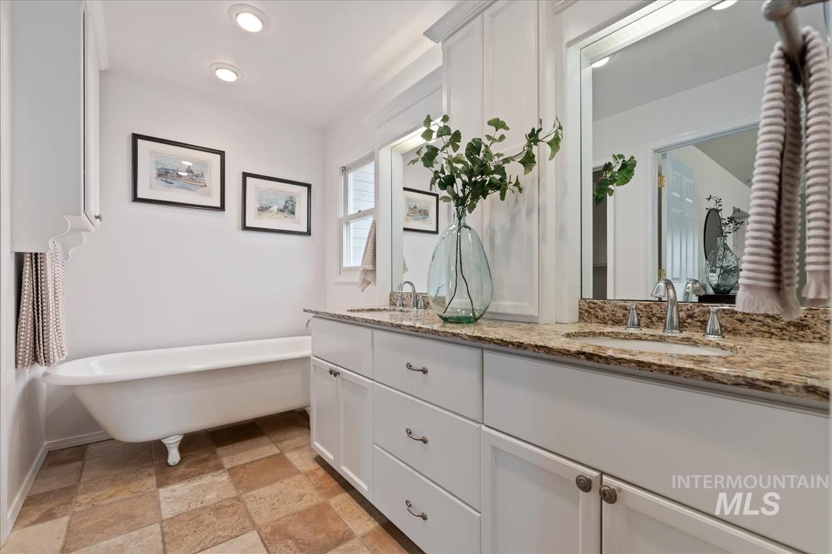 7790 Ustick Road Nampa, ID 83687 - Photo 17 of 41 Full bathroom featuring a freestanding tub, double vanity, and stone finish floors