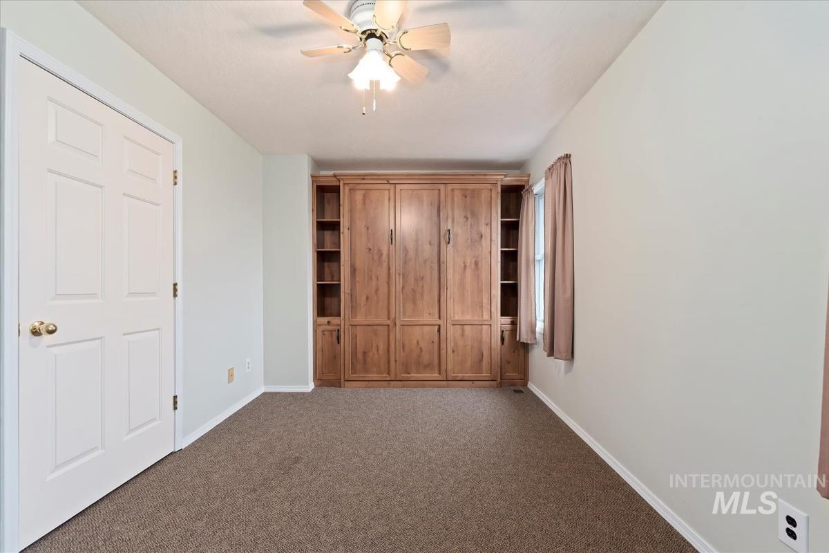 7790 Ustick Road Nampa, ID 83687 - Photo 21 of 41 Unfurnished bedroom featuring ceiling fan and dark colored carpet