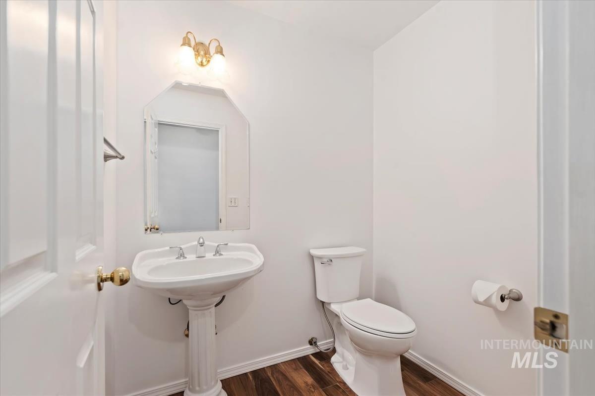7790 Ustick Road Nampa, ID 83687 - Photo 23 of 41 Half bath featuring dark wood-type flooring and baseboards