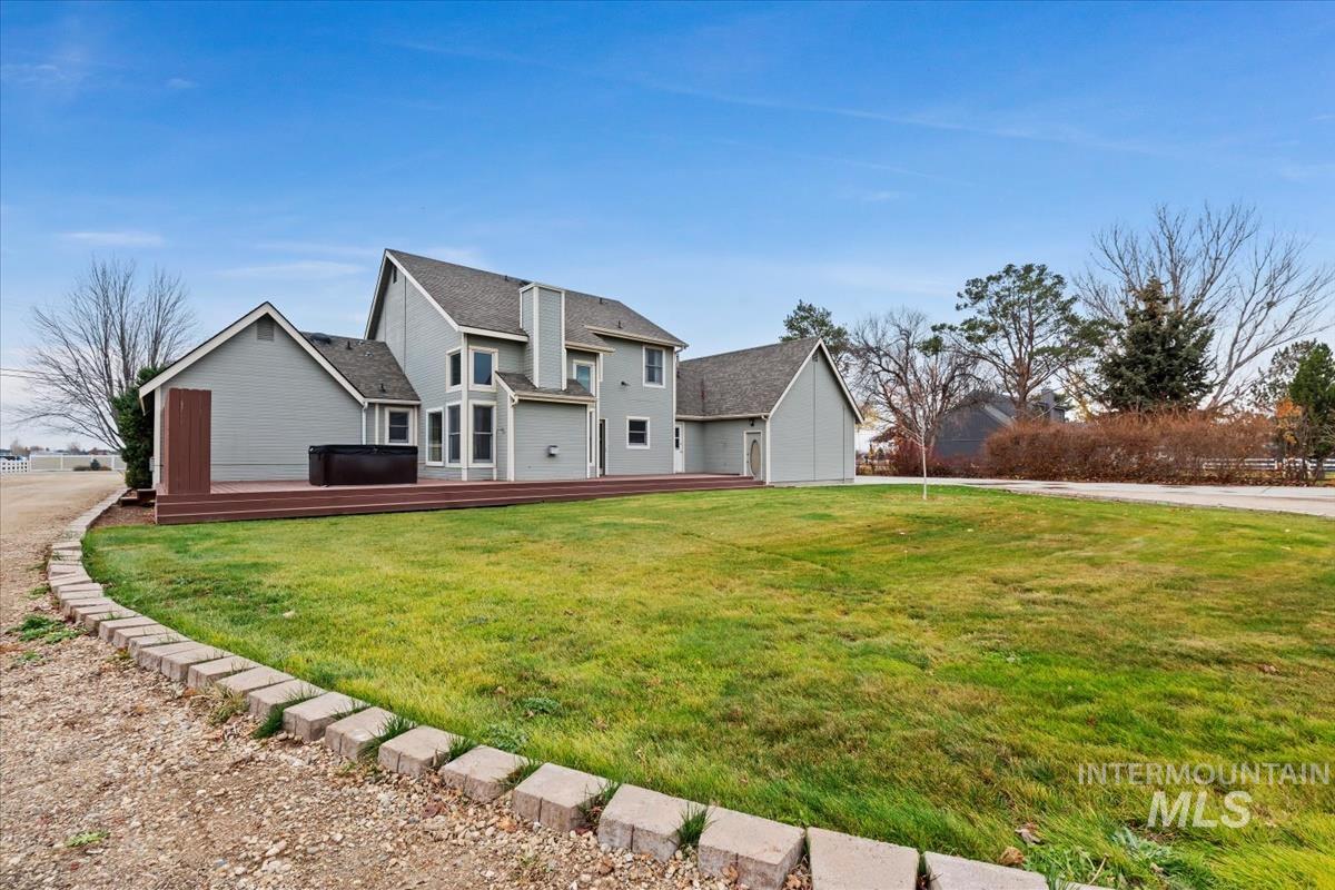 7790 Ustick Road Nampa, ID 83687 - Photo 34 of 41 Traditional home with a front yard, a hot tub, and a wooden deck