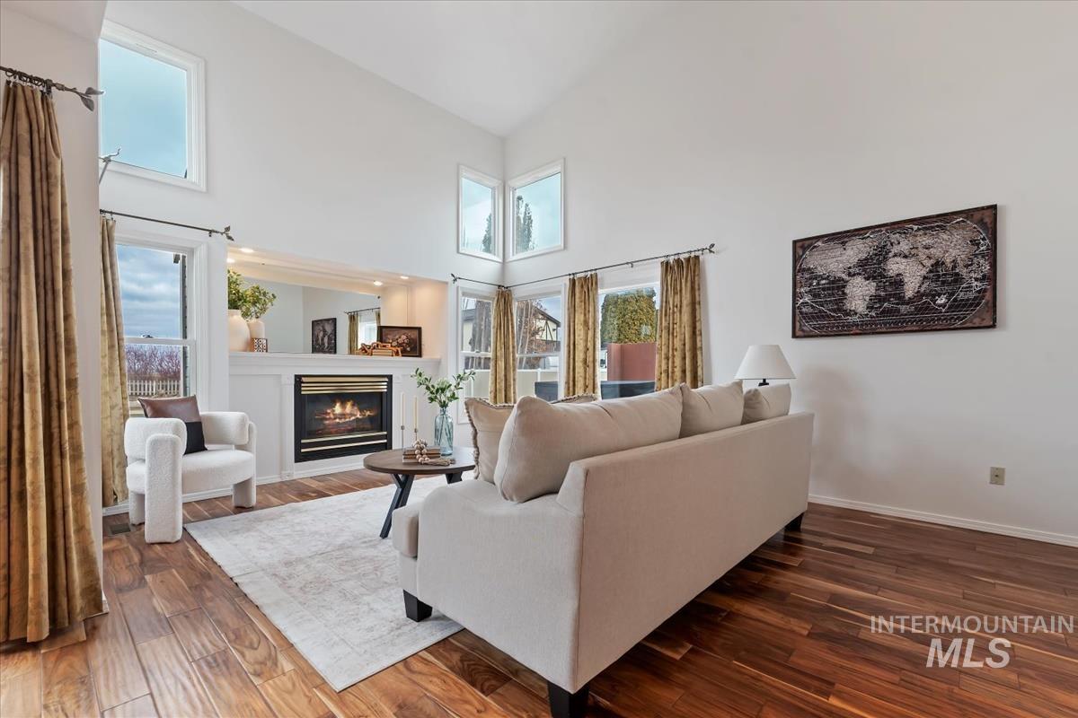 7790 Ustick Road Nampa, ID 83687 - Photo 7 of 41 Living room featuring a glass covered fireplace, a towering ceiling, and dark wood-style flooring