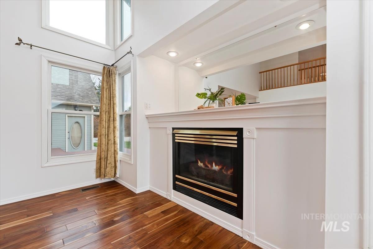7790 Ustick Road Nampa, ID 83687 - Photo 8 of 41 Unfurnished living room featuring a glass covered fireplace, dark wood-type flooring, and recessed lighting