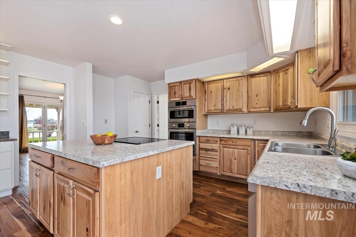 7790 Ustick Road Nampa, ID 83687 - Photo 10 of 41 Kitchen with light countertops, a kitchen island, dark wood-style floors, stainless steel double oven, and recessed lighting