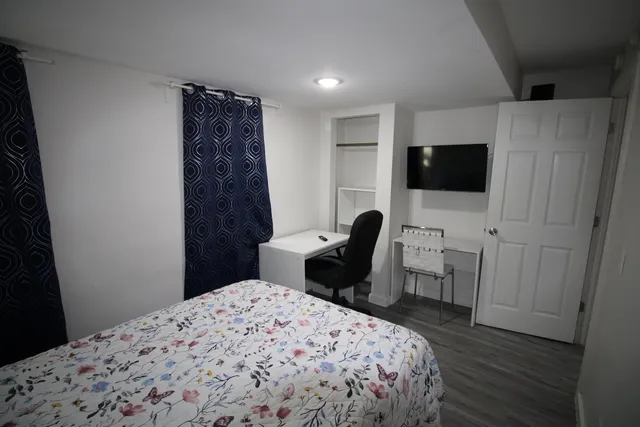 a bedroom with a bed and a flat screen tv