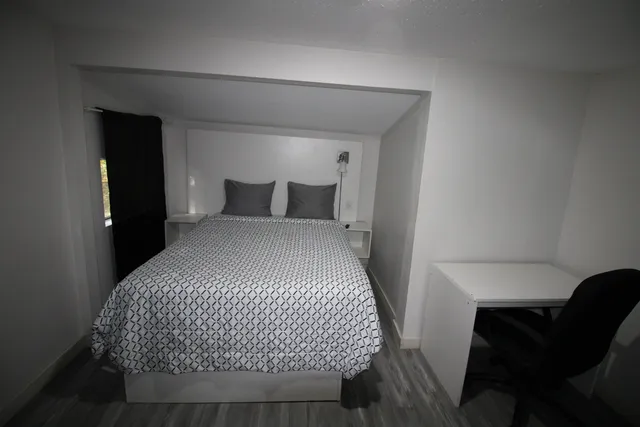 a bedroom with a bed and a lamp on table