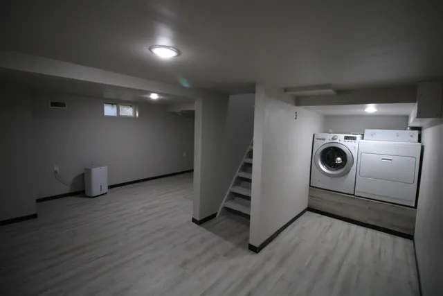 an empty room with wooden floor and white walls