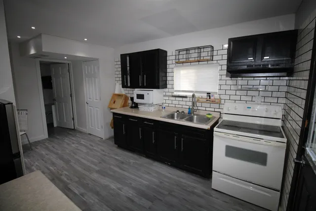 a kitchen with stainless steel appliances kitchen island granite countertop a sink and a stove top oven