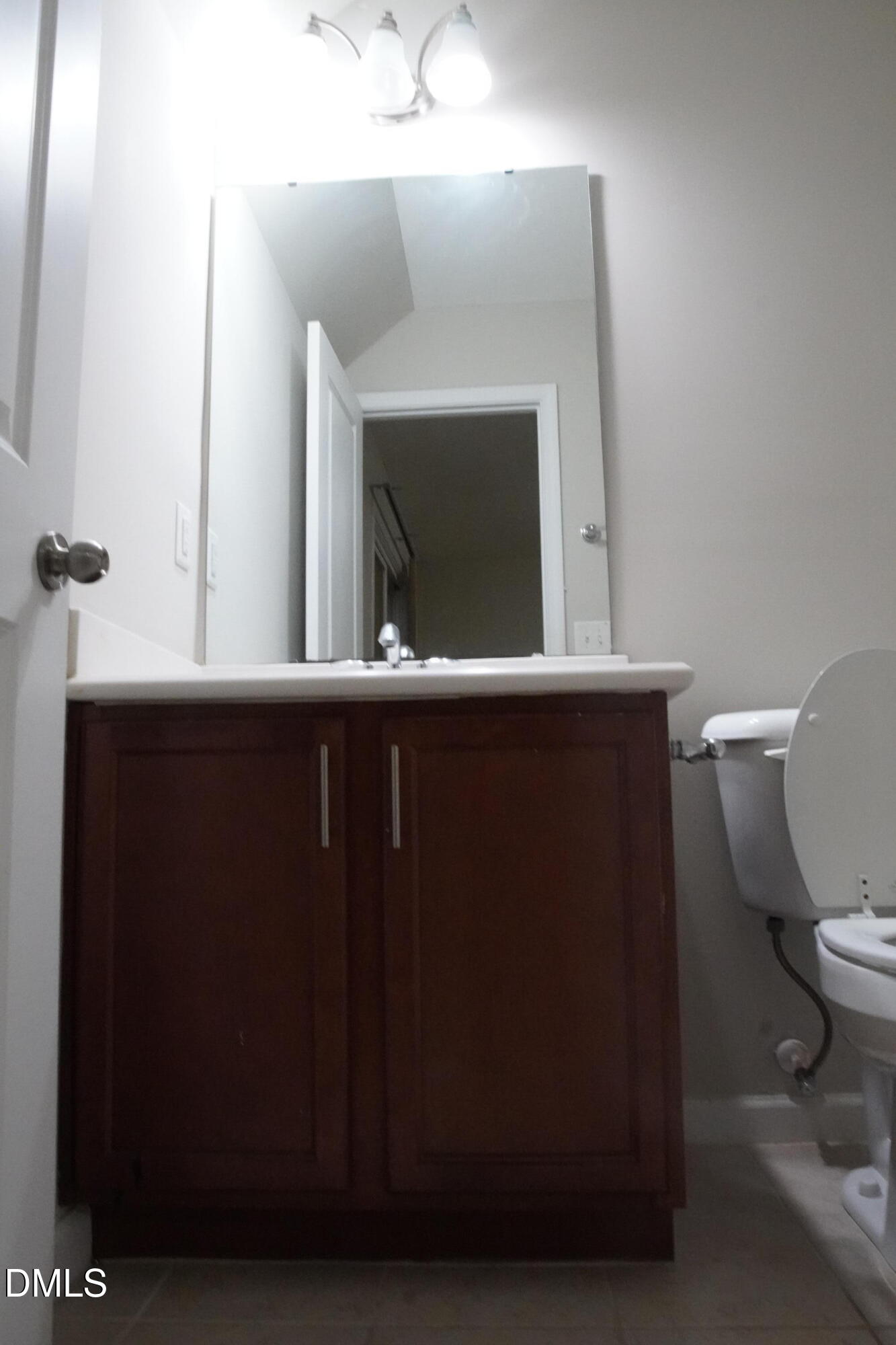 4039 Sykes Street Cary, NC 27519 - Photo 17 of 22 a bathroom with a toilet a mirror and a sink