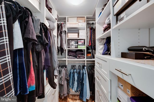 a view of walk in closet with clothes and shoes