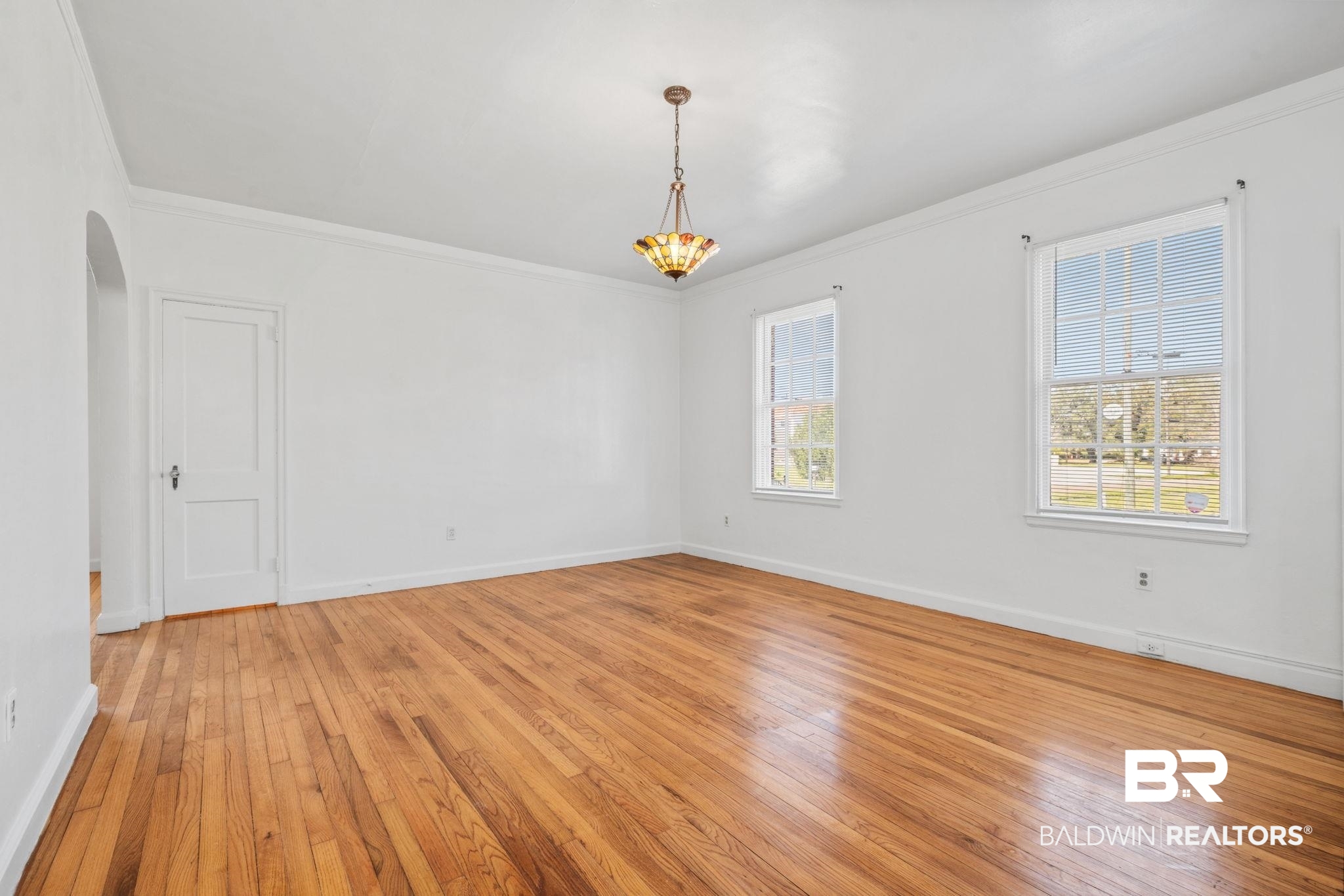 1707 Church Street Mobile, AL 36604 - Photo 23 of 43 Spare room featuring baseboards, arched walkways, light wood-style flooring, and ornamental molding
