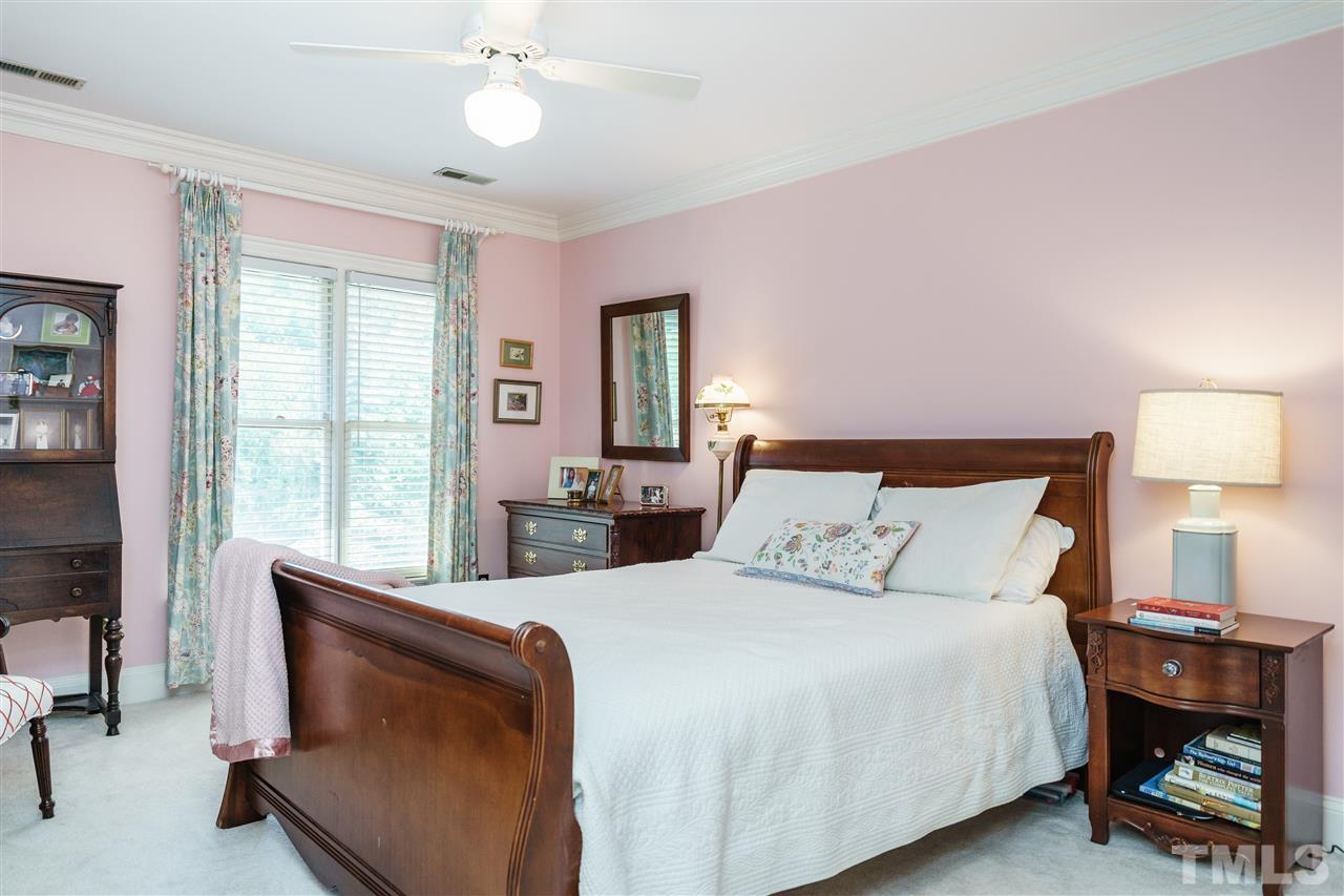 3320 Ridgecrest Court Raleigh, NC 27607 - Photo 19 of 24 a bedroom with a bed and a chandelier