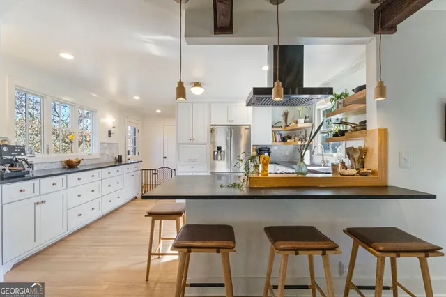 a kitchen with stainless steel appliances kitchen island granite countertop a table and chairs in it