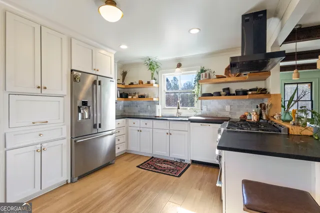 a kitchen with stainless steel appliances granite countertop a refrigerator sink and stove