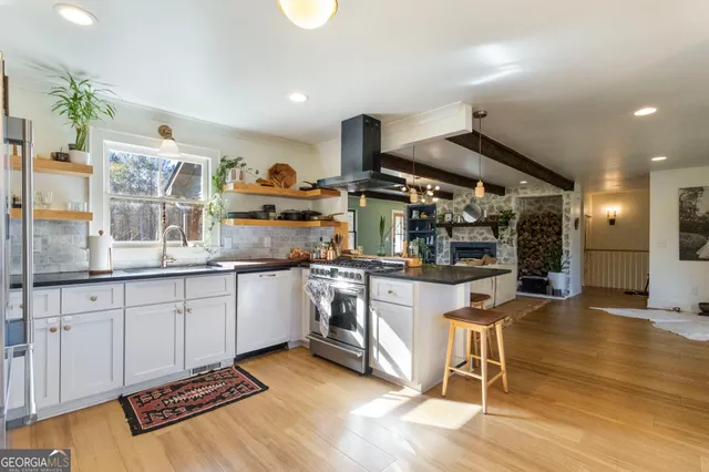 a kitchen with stainless steel appliances granite countertop a stove and a wooden floors