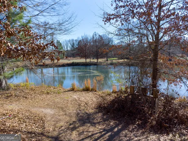 a view of a lake with lawn chairs and a fire pit