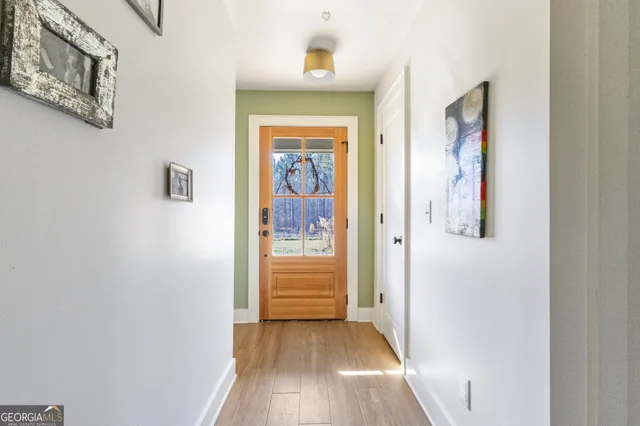 a view of a hallway with wooden floor and closet